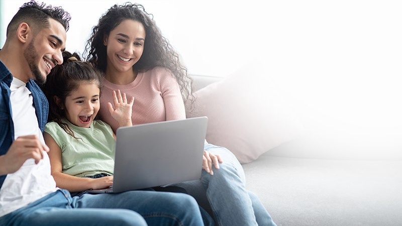 A smiling family with a laptop