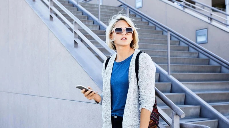 A woman with sunglasses and phone